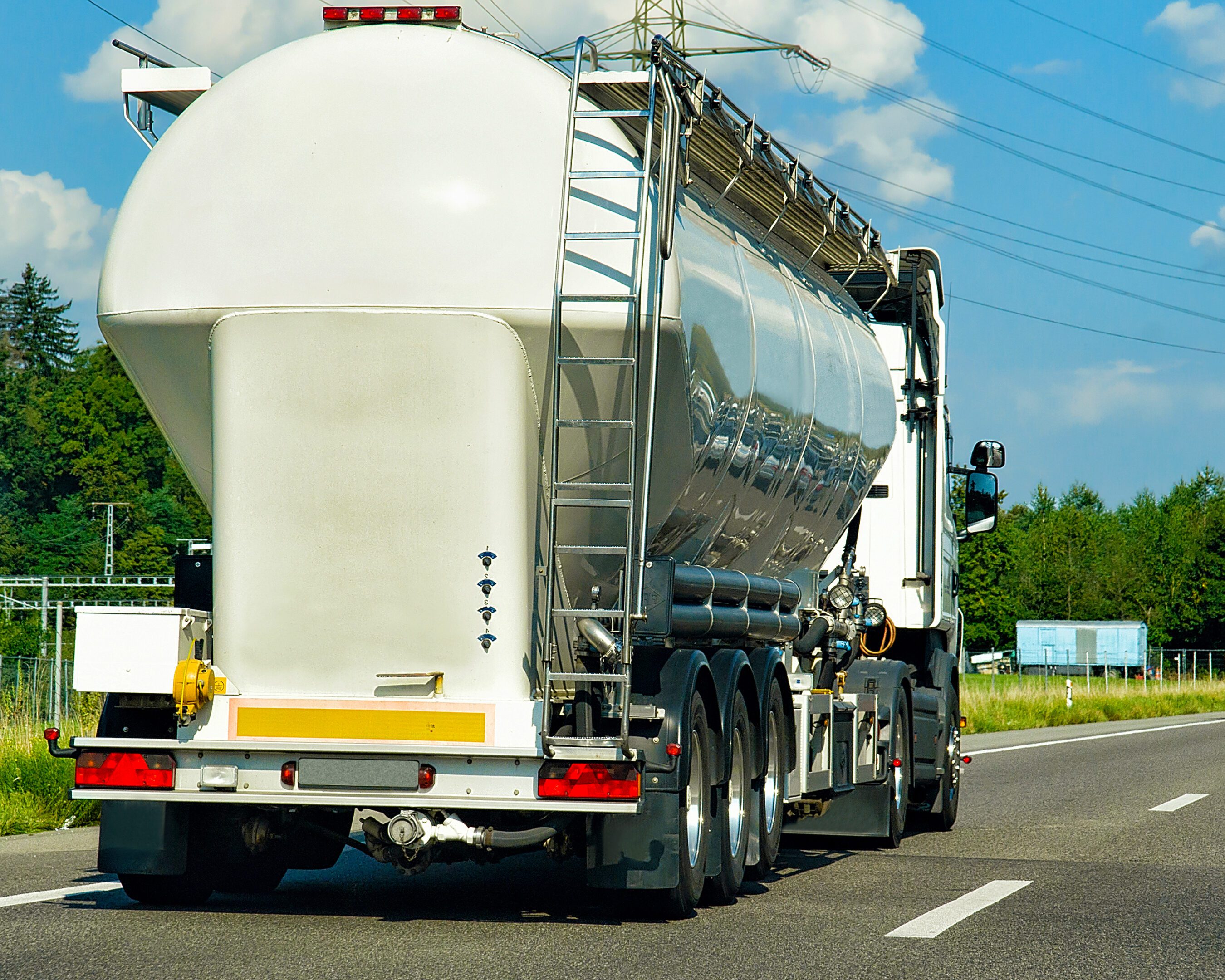 Truck with liquid or oil storage in road or highway of Switzerland. Lorry with service tanker cistern at logistics work. Semi trailer tank. Cargo car drive. Freight delivery. Transport export industry