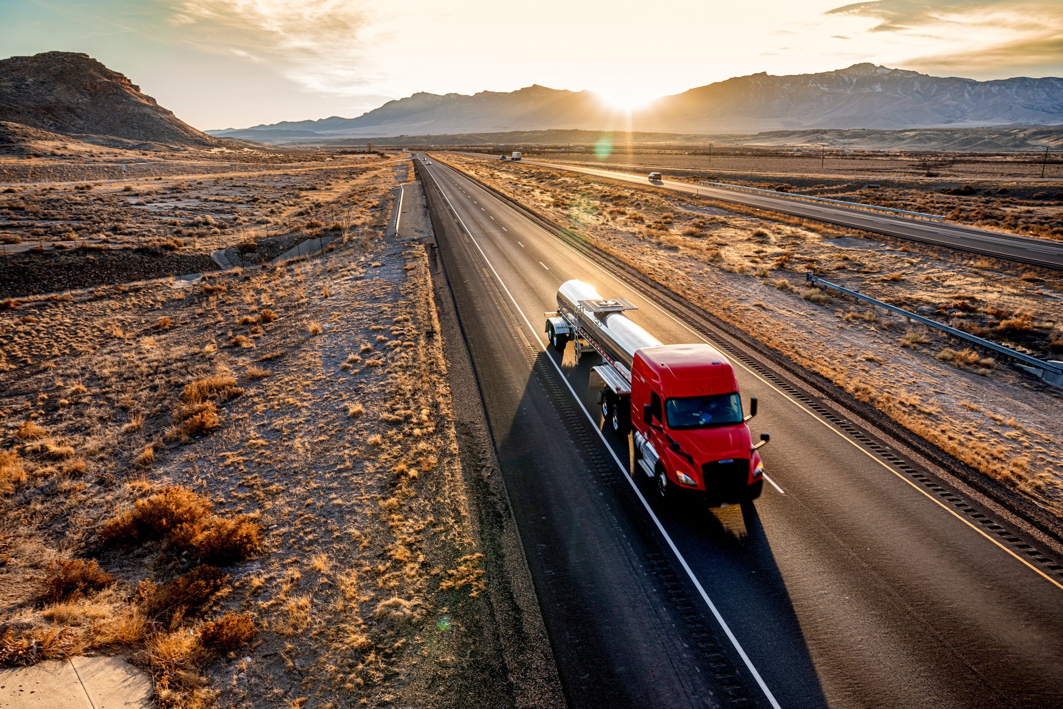Red Cab Tanker Truck Speeding Down Interstate Seventy in Utah during a beautiful sunset heading eastbound in the desert