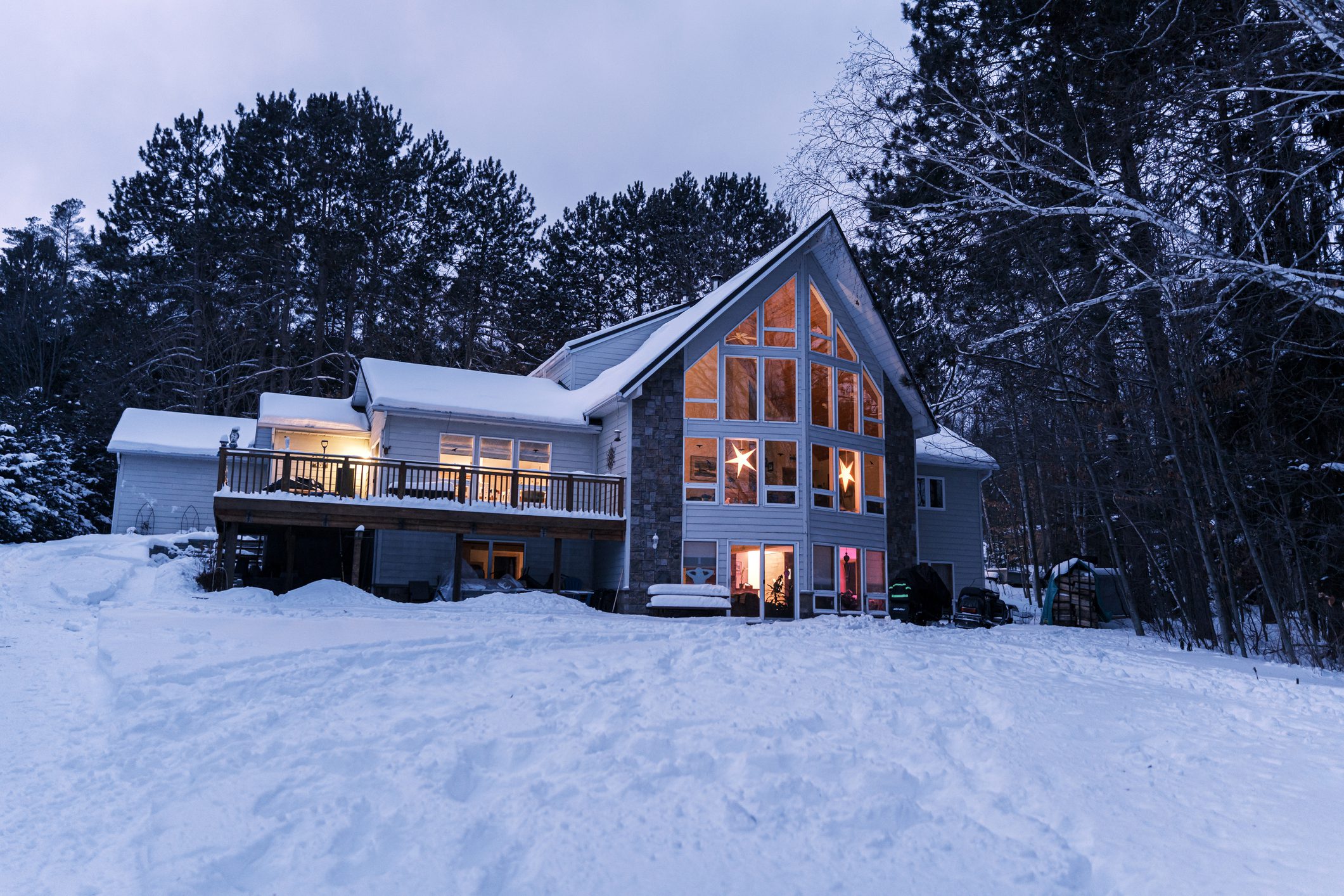 Lake House in winter time. Large home in wooded area on the water edge of the lake. Georgian Bay area of Ontario province, Canada.